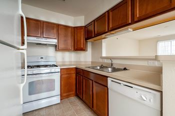 A kitchen with white appliances and wooden cabinets